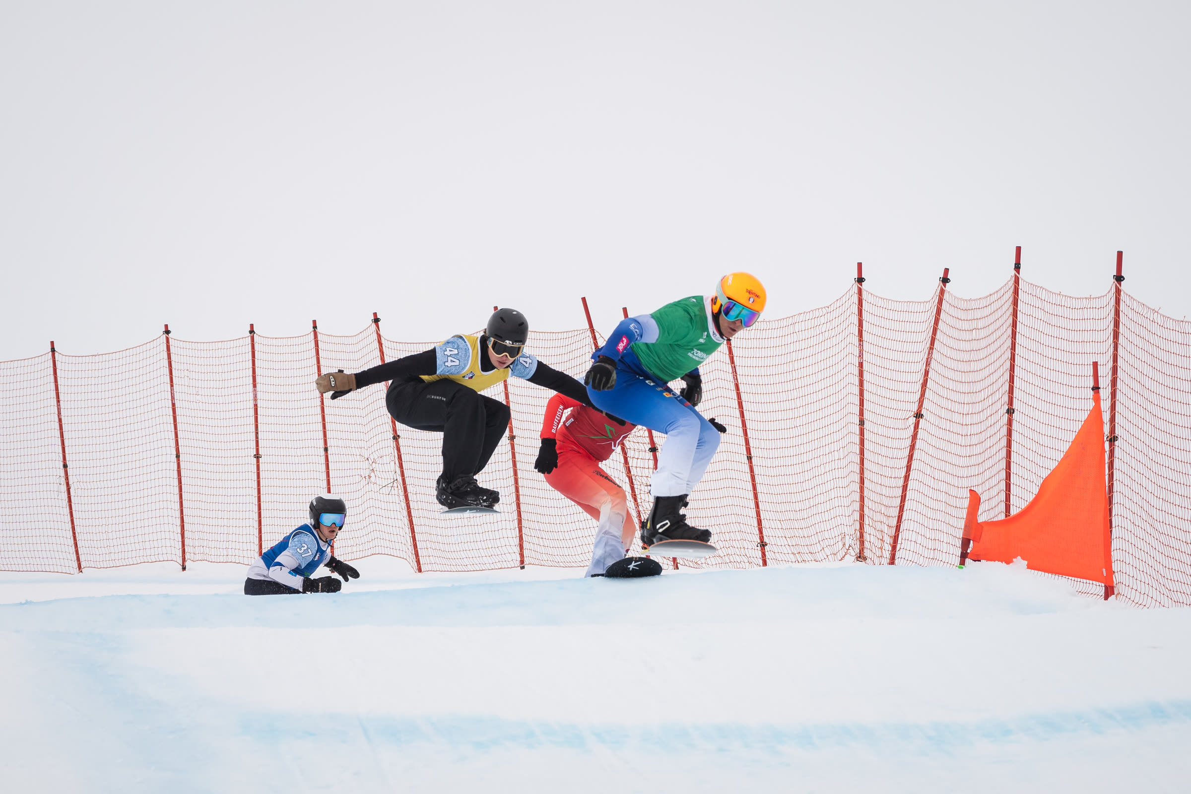 Snowboardcross riders racing side by side on course